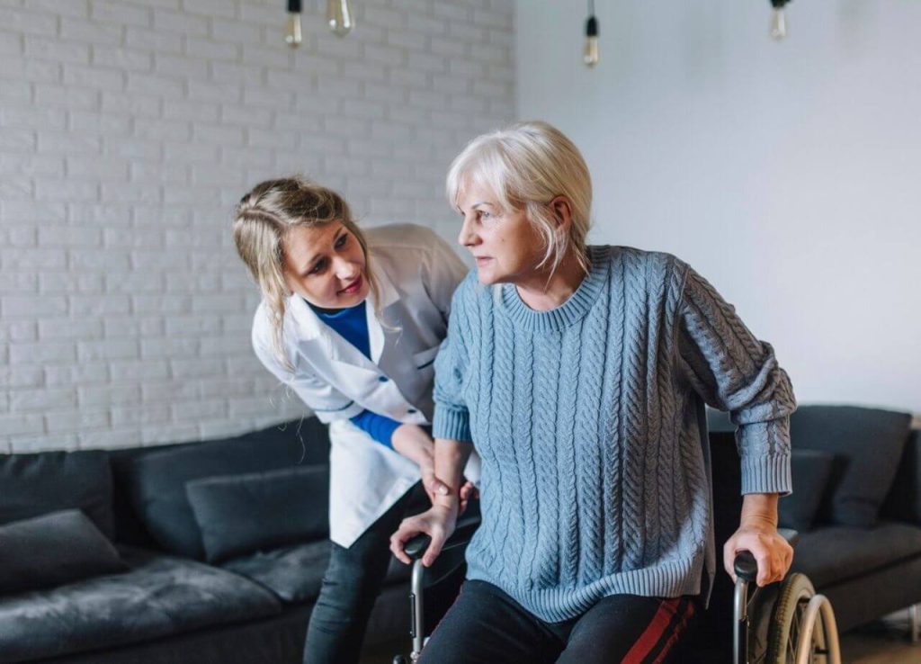 senhora-levantando-da-cadeira-de-rodas-com-a-fisioterapeuta